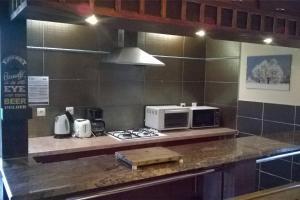 a kitchen with a stove and a microwave at Les Gites de l étang :Studio à 20 mn de Gerardmer in La Chapelle