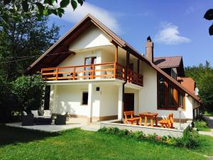 ein Haus mit einem Balkon und einem Tisch in der Unterkunft Samardzic House V in Plitvička Jezera