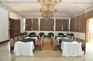 uma grande sala com mesas e cadeiras e um lustre em Ville Real Hotel em Santo Antônio do Leite