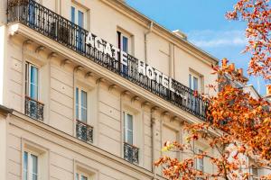 un bâtiment avec un panneau sur son côté dans l'établissement Agate Hôtel, à Paris