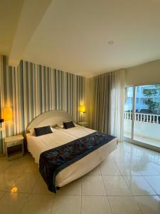 a bedroom with a large bed and a large window at Ouril Pontao Hotel in Santa Maria