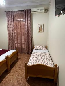 2 Betten in einem Zimmer mit Fenster in der Unterkunft Hotel plage d'or in Jijel