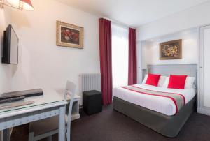 パリにあるAgate Hôtelのベッドとデスクが備わるホテルルームです。