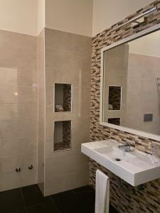 a bathroom with a sink and a mirror at Ouril Pontao Hotel in Santa Maria