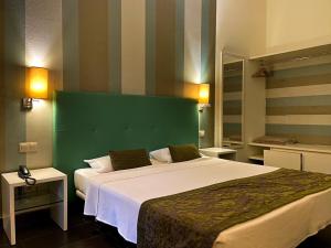 Schlafzimmer mit einem großen Bett mit einem grünen Kopfteil in der Unterkunft Ouril Pontao Hotel in Santa Maria