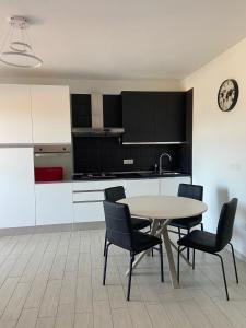 a kitchen with a table and chairs in a room at Medrano Modern Apartment in Olbia