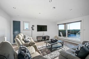 a living room with two couches and a tv at Sea View Luxury Apartment 3 bedrooms Free Parking - By Coast Apartments in Arbroath