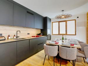 Appartement Courchevel, 4 pièces, 6 personnes - FR-1-664-14 في كورشوفيل: مطبخ مع طاولة وكراسي في مطبخ