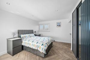 a white bedroom with a bed and a dresser and a window at Sea View Luxury Apartment 3 bedrooms Free Parking - By Coast Apartments in Arbroath
