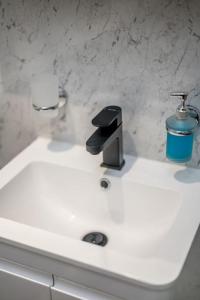 a sink with a faucet and a cup on it at Sea View Luxury Apartment 3 bedrooms Free Parking - By Coast Apartments in Arbroath