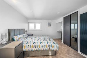 a bedroom with a bed and a dresser and a desk at Sea View Luxury Apartment 3 bedrooms Free Parking - By Coast Apartments in Arbroath