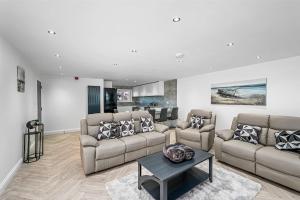 a living room with two couches and a table at Sea View Luxury Apartment 3 bedrooms Free Parking - By Coast Apartments in Arbroath