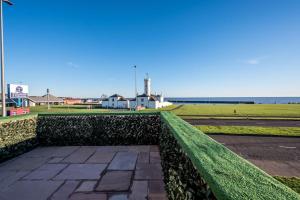 a stone walkway with a green hedge next to a street at Luxury Apartment with Sea Views in Arbroath