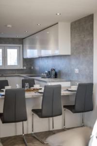 a kitchen with a table and chairs in it at Sea View Luxury Apartment 3 bedrooms Free Parking - By Coast Apartments in Arbroath