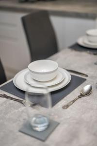 a table with a bowl and a plate on a napkin at Sea View Luxury Apartment 3 bedrooms Free Parking - By Coast Apartments in Arbroath