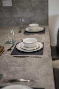 a table with plates and a bowl on top of it at Sea View Luxury Apartment 3 bedrooms Free Parking - By Coast Apartments in Arbroath