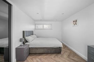 a white bedroom with a bed and a mirror at Sea View Luxury Apartment 3 bedrooms Free Parking - By Coast Apartments in Arbroath