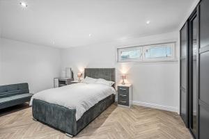 a white bedroom with a bed and a couch at Sea View Luxury Apartment 3 bedrooms Free Parking - By Coast Apartments in Arbroath