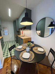 a dining room with a table with chairs and a mirror at ASF Home in Lisbon