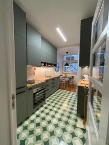- une cuisine avec des placards verts et un sol en damier dans l'établissement ASF Home, à Lisbonne