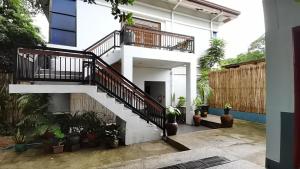 a white house with a staircase and plants at Coron town travellers inn in Coron