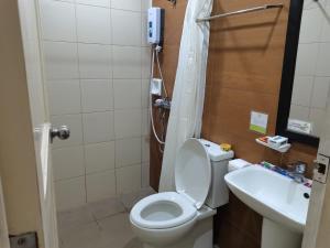 La salle de bains est pourvue de toilettes et d'un lavabo. dans l'établissement Coron town travellers inn, à Coron