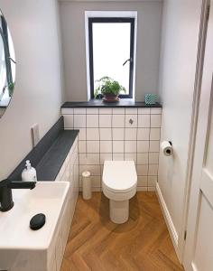a bathroom with a toilet and a sink and a window at Ilfracombe Townhouse: restored historic home in Ilfracombe +9 photos
