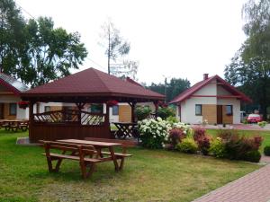 einem Picknicktisch und einem Pavillon vor einem Haus in der Unterkunft Miejsko Gminny Ośrodek Sportu i Rekreacji in Łopuszno