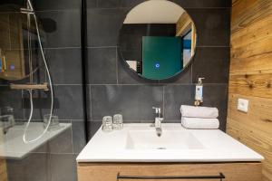 a bathroom with a sink and a mirror at Hotel Les Lutins in Les Deux Alpes