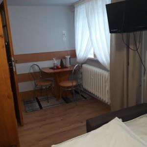 una camera con tavolo e sedie e una camera con letto di Willa ASPEN a Szklarska Poręba