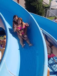 two girls sliding down a slide at a water park at Hotel Maris Stella in Riccione