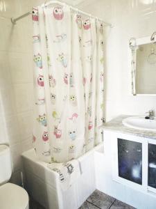 a bathroom with a toilet and a shower curtain at La Encina in Alhama de Granada