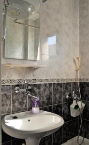 ein Badezimmer mit einem weißen Waschbecken und einem Spiegel in der Unterkunft Yeshill Apart & Studio in Budva