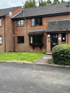 a brick house with a front door and grass at Newly Refurbished Luxury Hotel Style Accommodation in Milton Keynes