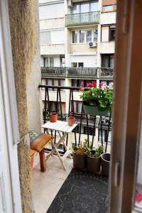 a balcony with a table and potted plants and a building at Blumen Apartment in Budapest