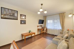 a living room with a couch and a table at NORTH Apartments Blue-Velvet, parking in Ustka