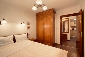 a bedroom with a bed and a wooden cabinet at NORTH Apartments Blue-Velvet, parking in Ustka