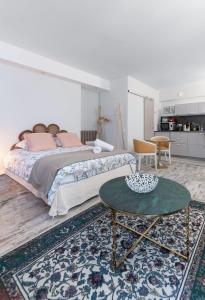 ein Schlafzimmer mit einem großen Bett und einem Tisch in der Unterkunft Résidence Aristide Briand - Appartements en Centre Ville in Vichy