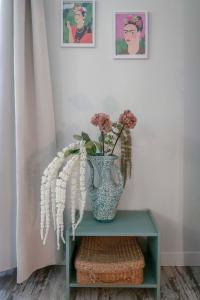 eine Vase mit Blumen auf einem Tisch in der Unterkunft Résidence Aristide Briand - Appartements en Centre Ville in Vichy
