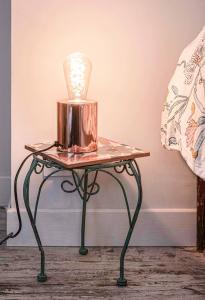 une table avec une lampe au-dessus dans l'établissement Résidence Aristide Briand - Appartements en Centre Ville, à Vichy