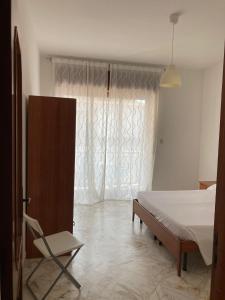 1 dormitorio con 1 cama, 1 silla y 1 ventana en Tizi Apartments, en Maiori