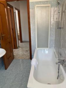 a bathroom with a white tub and a shower at Tizi Apartments in Maiori