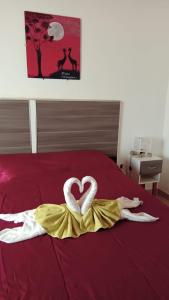 Una cama con dos toallas en forma de corazón. en Cabañas Nefesh en Carpintería