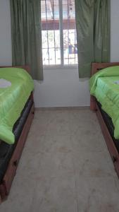 2 camas en una habitación con ventana en Cabañas Nefesh en Carpintería
