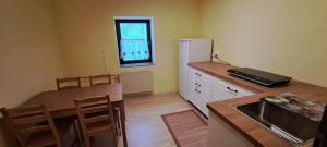 コバリードにあるApartma Humarの木製のテーブルと冷蔵庫のあるキッチン