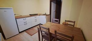 een keuken met een houten tafel en een koelkast bij Apartma Humar in Kobarid