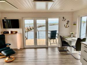 an office with a desk and a table with chairs at Hausboot Bali in Fehmarn