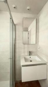 Baño blanco con lavabo y espejo en Sunset Los Lances - Tarifa, en Tarifa