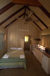 a bedroom with a bed and a ceiling fan at Central Tourist Park in Mackay