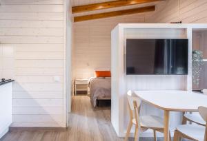 um quarto com uma mesa, uma cama e uma televisão em Càmping Vall De Camprodon em Camprodon